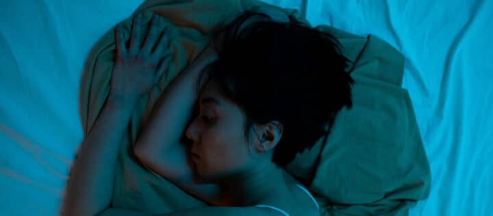 Kvinna sömnlös i sängen